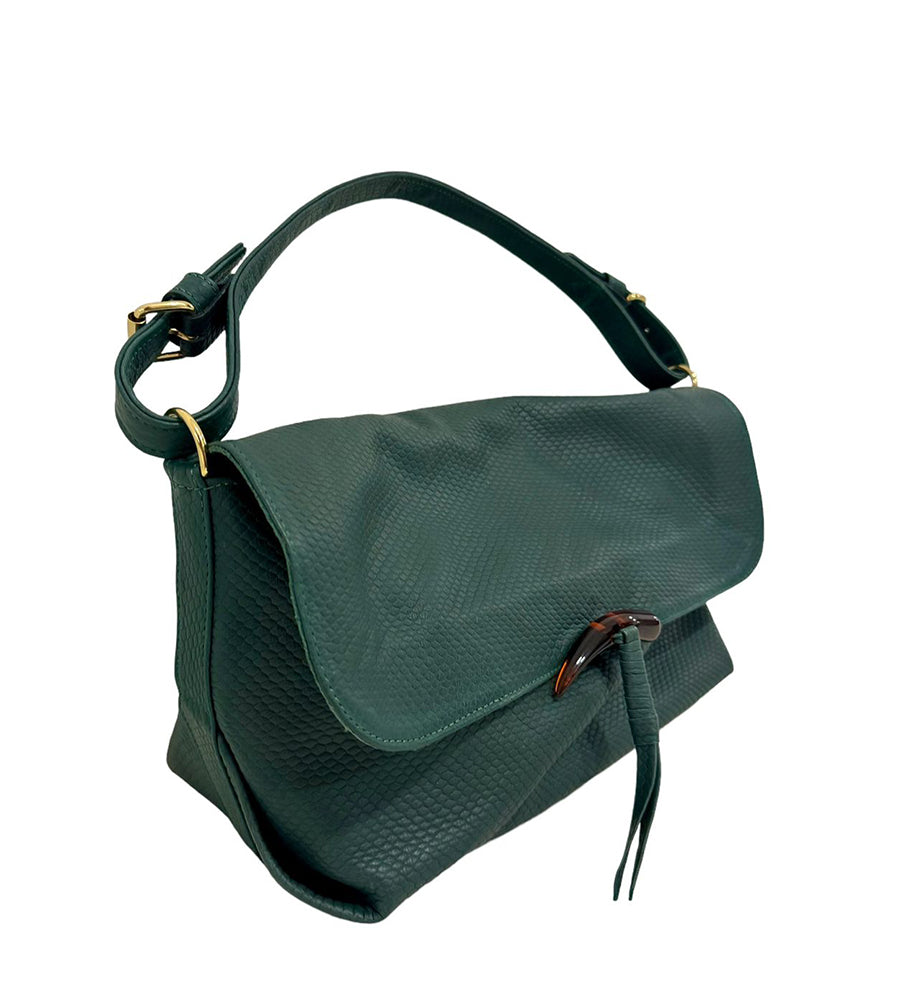 Bolsa baguete na cor verde de lado virada para a direita com a alça de ombro esticada. A bolsa possui um fecho no formato de dente feito em resina.